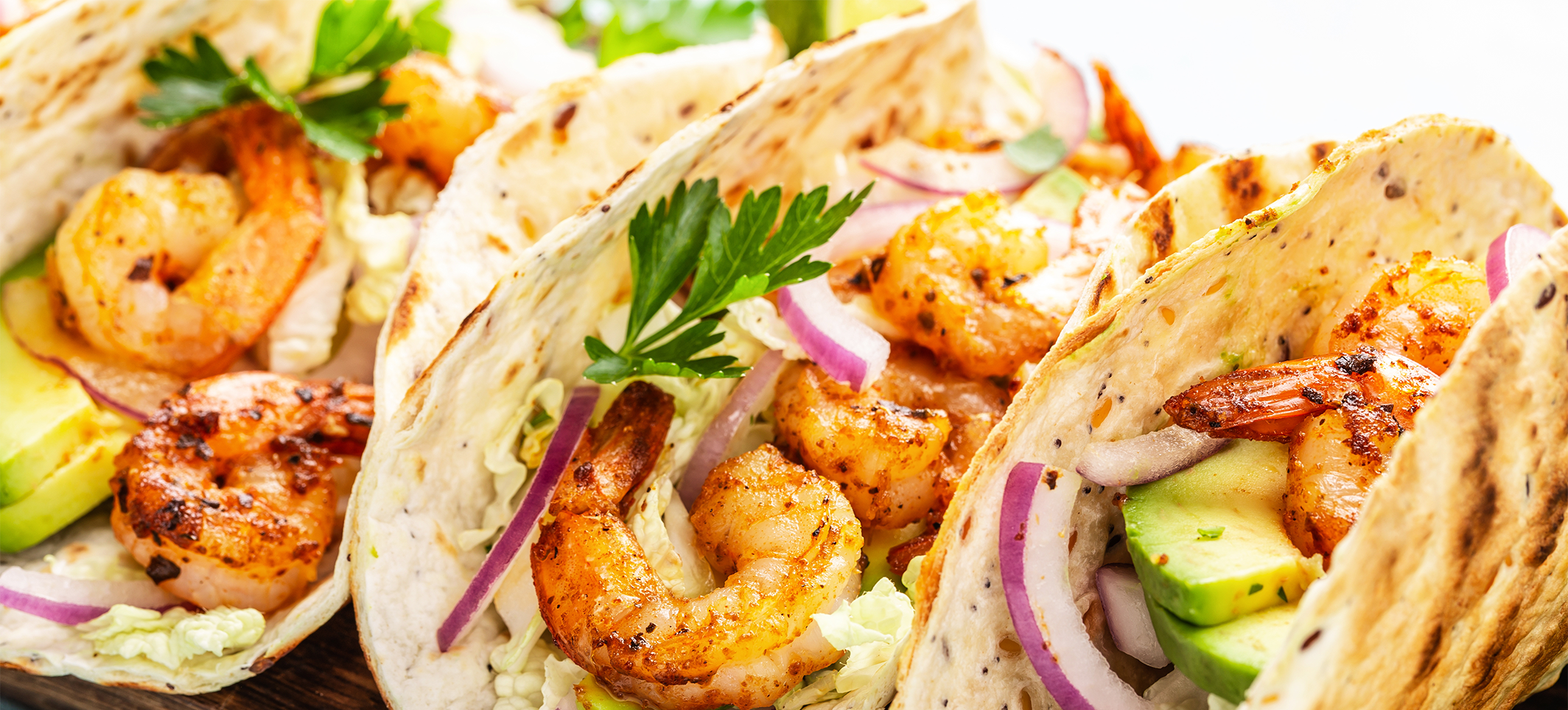 three shrimp tacos on a platter